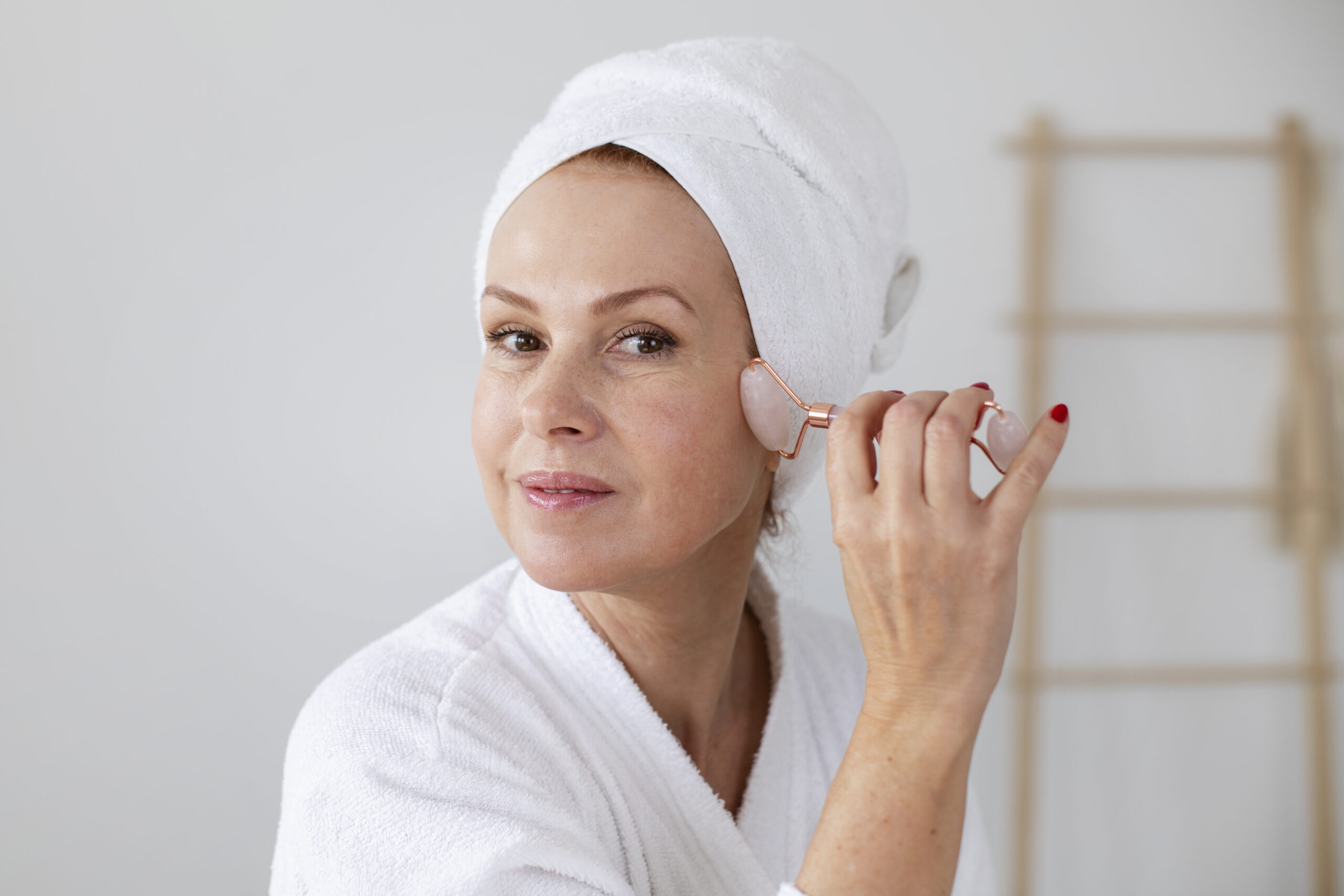 Wanita melakukan perawatan wajah dengan gua sha, salah satu tahapan rutinitas skincare